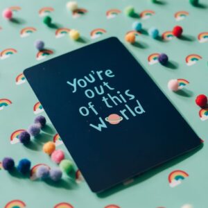 Inspirational card with playful pom-poms on a vibrant colorful background.